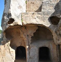 Explore well-preserved ancient rock-cut tombs with distinct entrances, showcasing historical architecture.